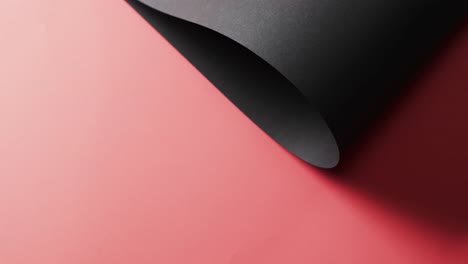 Nahaufnahme-Einer-Schwarzen-Papierrolle-Und-Kopierraum-Auf-Rotem-Hintergrund