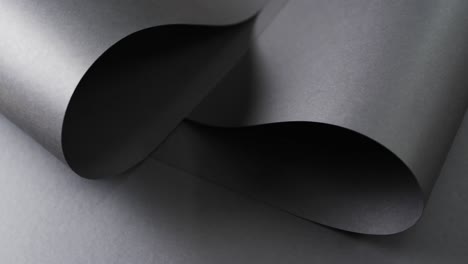 Close-up-of-rolls-of-black-paper-and-copy-space-on-black-background