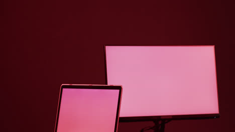 Video-Von-Computer-Und-Laptop-Mit-Leeren-Bildschirmen,-Kopierraum-Auf-Neonfarbenem-Hintergrund