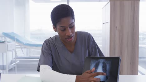 Doctora-Afroamericana-Usando-Tableta-Haciendo-Videollamadas-En-El-Hospital,-Cámara-Lenta