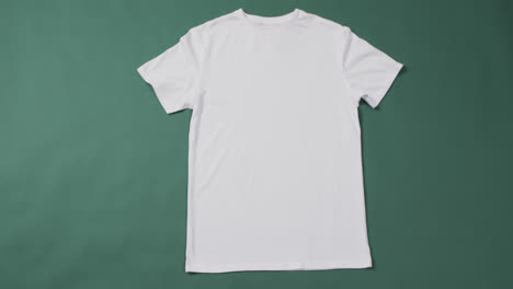 Video-Eines-Weißen-T-Shirts-Mit-Etikett-Und-Kopierraum-Auf-Grünem-Hintergrund