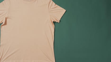 Video-of-yellow-t-shirt-with-tag-and-copy-space-on-green-background