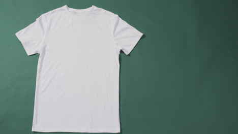 Video-of-white-t-shirt-with-tag-and-copy-space-on-green-background