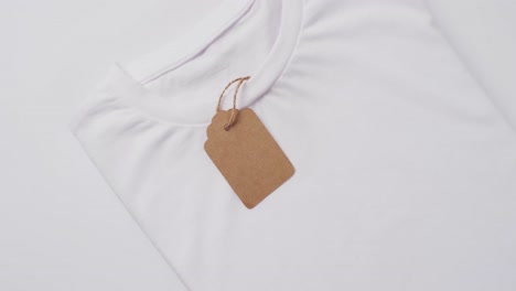 Video-Eines-Weißen-Gefalteten-T-Shirts-Mit-Etikett-Und-Kopierraum-Auf-Weißem-Hintergrund