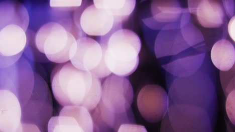 Video-of-flickering-white-and-purple-bokeh-spots-of-light-with-copy-space
