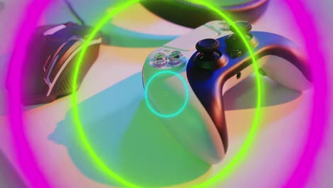 Animation-of-neon-light-trails-over-video-game-computer-equipment