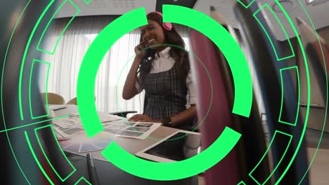 Animation-of-green-circles-over-african-american-fashion-designer-listening-music-at-desk-in-office