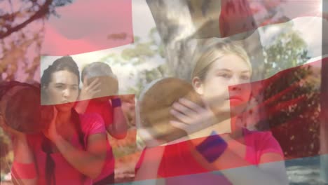 Animation-of-flag-of-switzerland-over-diverse-female-players-carrying-log-on-shoulder