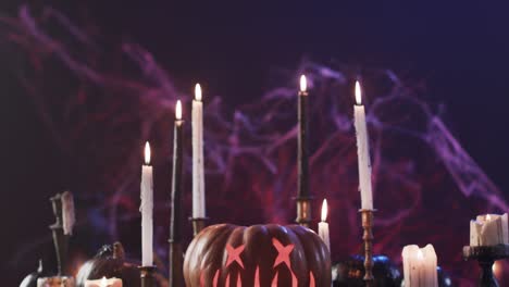 Video-of-halloween-carved-pumpkin,-candles-and-smoke-with-copy-space-on-purple-background