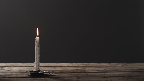Video-of-halloween-candle-with-smoke-and-copy-space-on-wooden-and-black-background