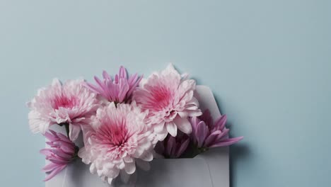 Video-Eines-Straußes-Mehrfarbiger-Blumen-Im-Umschlag-Und-Kopierraum-Auf-Blauem-Hintergrund