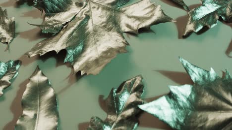 Video-of-halloween-autumn-metallic-leaves-with-copy-space-on-green-background