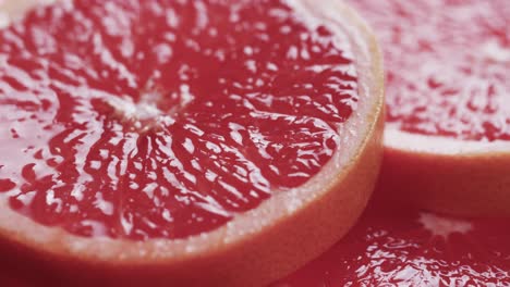 Micro-video-of-close-up-of-red-grapefruit-slices-with-copy-space