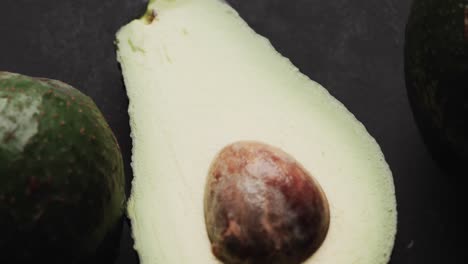 Micro-video-of-close-up-of-avocados-with-copy-space-on-black-background