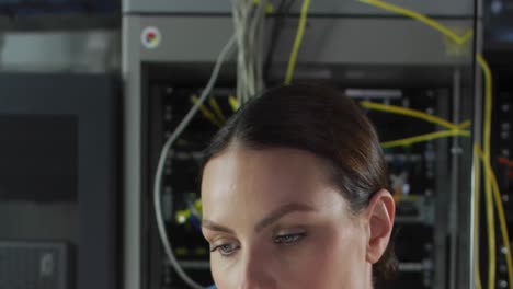 Animation-of-data-processing-over-close-up-of-caucasian-female-engineer-working-at-server-room