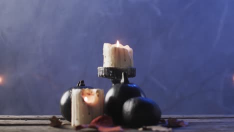 Video-of-carved-pumpkins,-candles-and-smoke-with-copy-space-on-purple-background