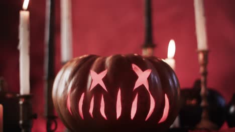 Video-of-halloween-carved-pumpkin,-candles-and-smoke-with-copy-space-on-red-background