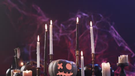 Video-of-halloween-carved-pumpkin,-candles-and-smoke-with-copy-space-on-purple-background
