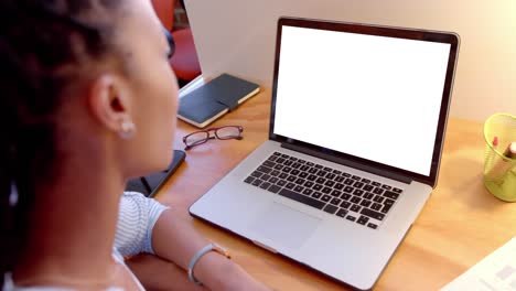 African-american-casual-businesswoman-at-desk-watching-laptop-with-copy-space-on-screen,-slow-motion
