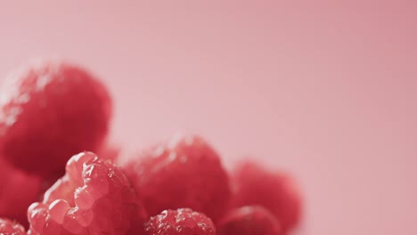 Micro-video-of-close-up-of-raspberries-with-copy-space-on-red-background