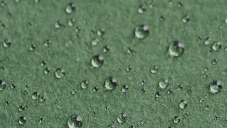 Micro-video-of-close-up-of-water-drops-with-copy-space-on-green-background