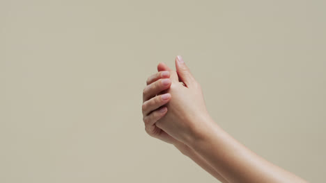 Hands-of-asian-woman-on-beige-background-with-copy-space,-slow-motion