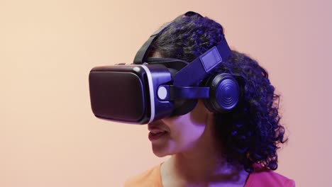Video-Einer-Gemischtrassigen-Frau,-Die-Ein-VR-Headset-Auf-Beigem-Hintergrund-Verwendet
