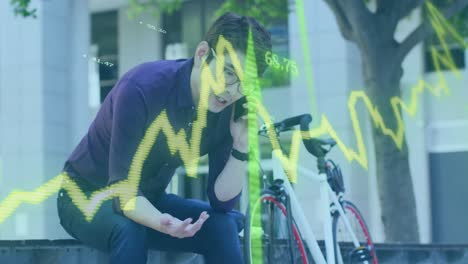 Animation-of-stock-market-data-processing-against-asian-man-talking-on-smartphone-on-the-street