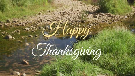 Animation-of-happy-thanksgiving-text-banner-against-grass,-rocks-and-river-bed