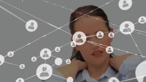 Animation-of-network-of-profile-icons-over-caucasian-businesswoman-holding-her-neck-in-pain