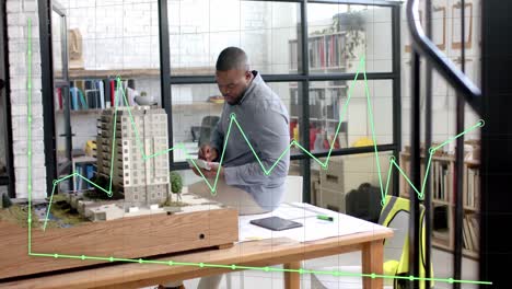 Datenverarbeitung-Auf-Einem-Diagramm-über-Einem-Afroamerikanischen-Männlichen-Architekten,-Der-Das-Gebäudemodell-Studiert