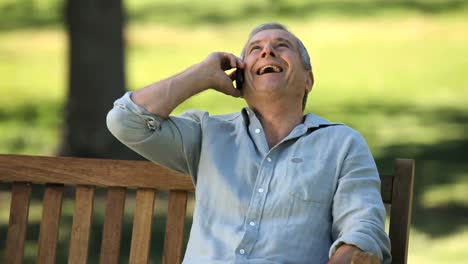 Elderly-man-talking-on-the-phone-on-a-bench