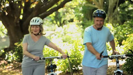 Elderly-couple-walking-and-pushing-bikes