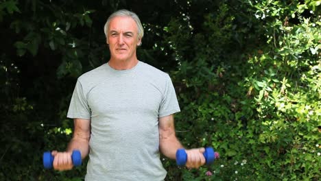 Elderly-man-working-her-muscles-with-dumbbells