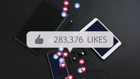 Animation-of-likes-growing-number-with-icons-over-smartphone-and-tablets-on-black-background