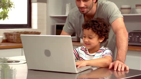 Smiling-Hispanic-father-on-computer-with-his-son