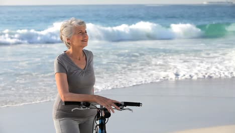 Ältere-Frau-Wartet-Mit-Einem-Fahrrad