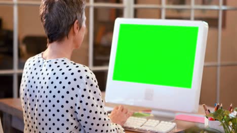 Casual-businesswoman-using-computer-with-green-screen