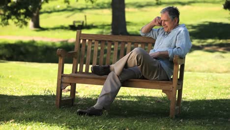Old-male-talking-on-the-phone-on-a-bench