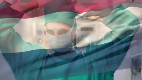 Animation-of-waving-netherlands-flag-over-caucasian-female-surgeon-wearing-surgical-mask-at-hospital
