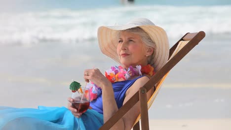 Elderly-woman-looking-at-the-horizon-with-a-cocktail