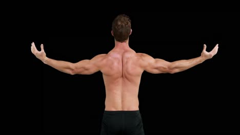 Rear-view--of-muscular-man-outstretching-his-arms