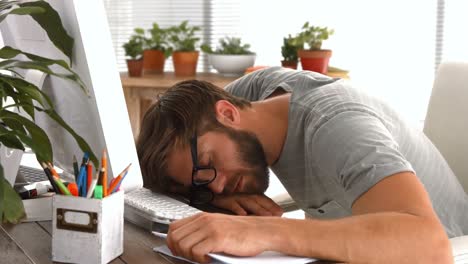Casual-businessman-sleeping-on-desk-