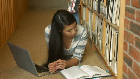 Estudiante-Leyendo-Un-Libro-En-La-Biblioteca