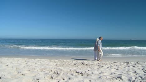 Elderly-man-walking-on-the-beach-wither-his-wife