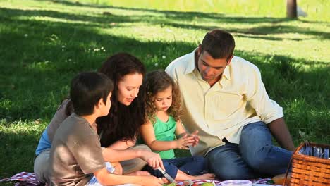 Parents-enjoying-a-picnic-with-children-on-a-tablecloth