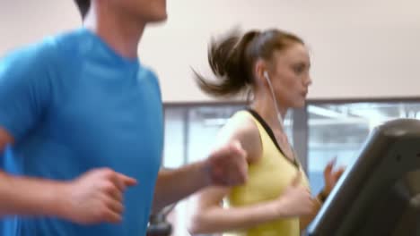 Couple-running-on-treadmills-in-gym