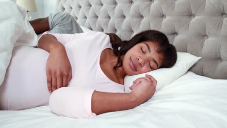 Pregnant-couple-sleeping-in-bed