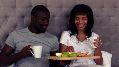 Smiling-couple-taking-breakfast-on-bed