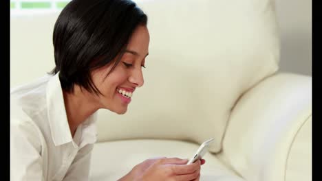 Happy-woman-sending-text-on-couch